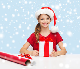 smiling girl in santa helper hat with gift box