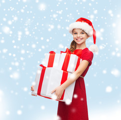 girl in santa helper hat with many gift boxes