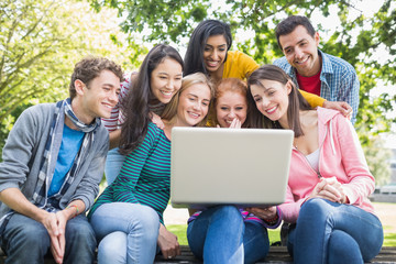 Fototapeta na wymiar College students using laptop in park