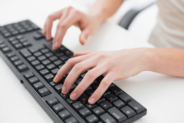 Midsection of a businesswoman typing on keyboard