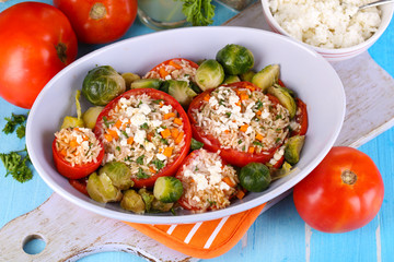 Stuffed tomatoes in bowl on wooden table close-up