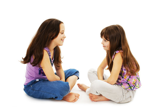 Two Little Girls Talking On White Background