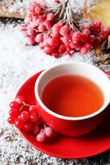Still life with viburnum  tea in cup, berries and snow,