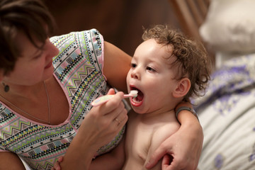 Mother brushes her child teeth