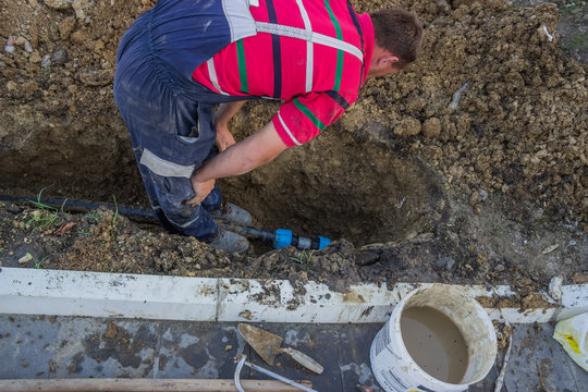 utility worker in trench repair the broken pipe 4