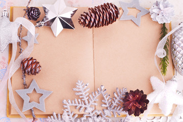Open old book with brown paper, cones and felt stars