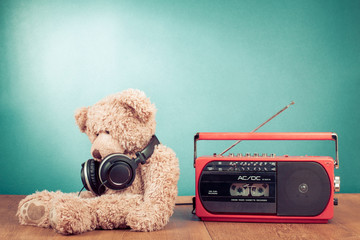 Retro toy Teddy Bear with headphones and radio recorder