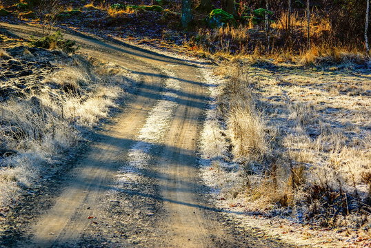 Curved frosty dirt road in the countryside in winter.