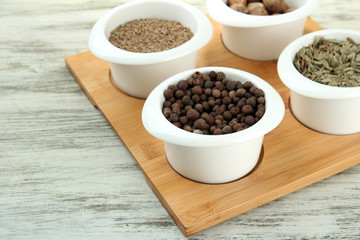 Assortment of spices in  white  bowls, on wooden background