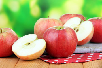 Ripe apples on  wooden table, on bright background