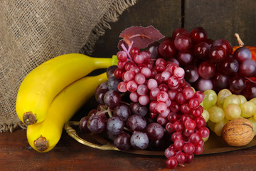 Golden tray with fruits on wooden background