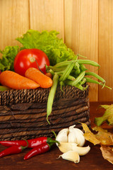 Different vegetables in basket with yellow leaves