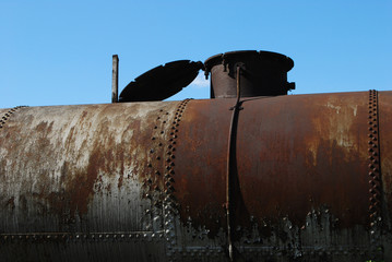 Weathered aged rusty railway tank on blue sky