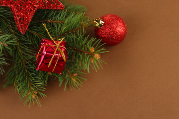 Beautiful Christmas decorations on fir tree on brown background