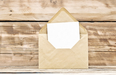 Blank postcard and envelope on old wooden background