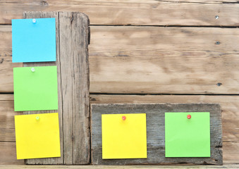 colorful reminder notes attached on a old wooden signboard