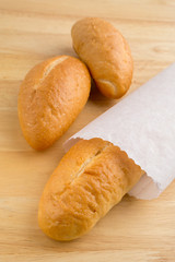 Bread in the paper bag on the wooden table