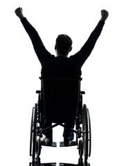 rear view handicapped man arms raised  in wheelchair silhouette