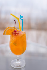 Orange juice in wine glass with cherry fruit