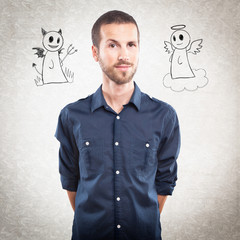 Young handsome man with angel and devil