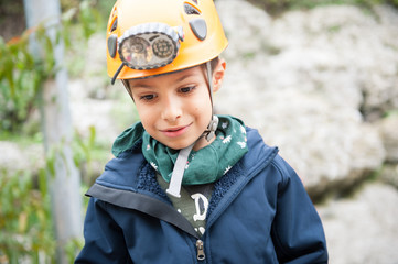 Young kid wearing helmet for cave exploration.