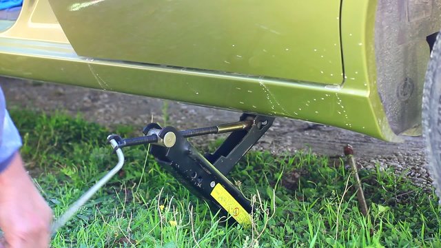 man using jack for car