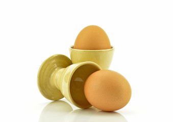 Jajka z ceramicznymi kieliszkami na białym tle © CUKMEN