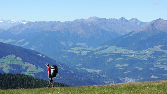 Paraglider with backpack walking on the top of the mountains