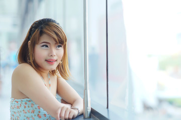 Young beautifull woman stand near glass wall in office