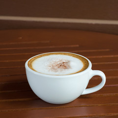 a cup of coffee on wood table