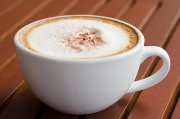 a cup of coffee on wood table