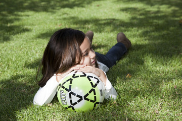 Ni&ntilde;a con la cabeza apoyada en una pelota