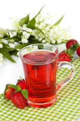 Delicious strawberry tea on table on white background