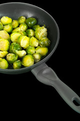 Fresh brussels sprouts in pan on cooking surface close-up