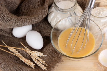 Ingredients for dough on wooden table on wooden background