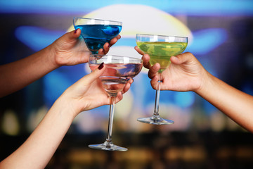 Cocktails in hands in nightclub