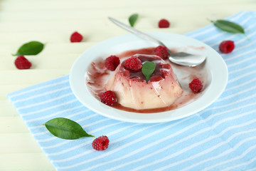 Panna Cotta with raspberry sauce, on wooden background