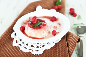 Panna Cotta with raspberry sauce, on wooden background