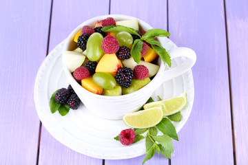 Fruit salad in cup on wooden table