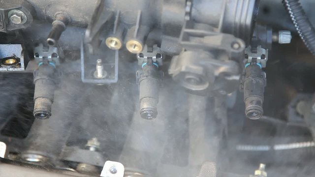 Automotive, car engine injectors splashing gasoline
