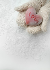Female hands in mittens with red heart, close-up