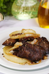 Appetizing fried chicken livers on plate close-up