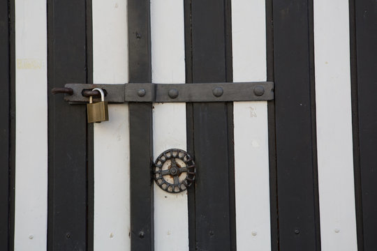 Schloss und Riegel an gestreifter Wand