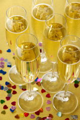 Glasses with champagne on shiny background