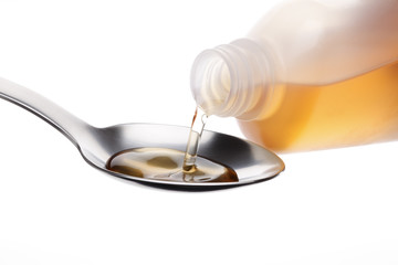 Bottle pouring Medicine Syrup in Spoon