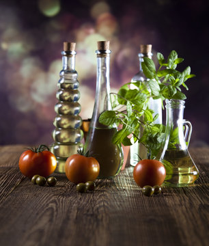 Bottles of olive oil, fresh olives and basil, tomatoes
