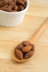 Roasted salted almonds in wooden spoon