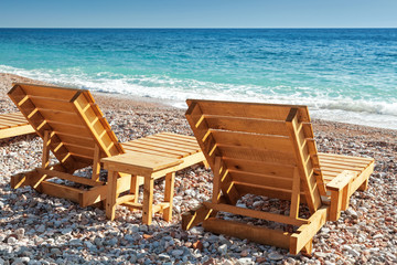Two wooden sun loungers stand on the Adriatic Sea