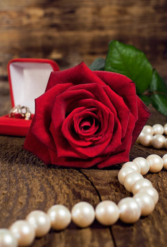 pearl necklace, red rose and gold ring