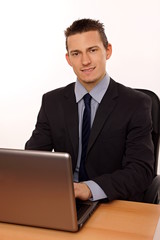 Young businessman at suit works on the notebook
